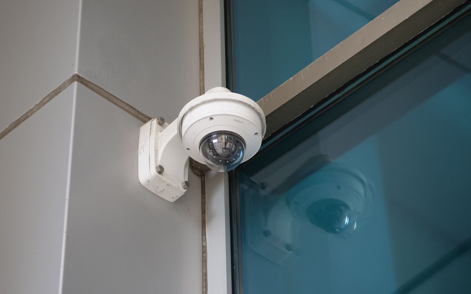 Security camera mounted on a building corner for surveillance and safety.