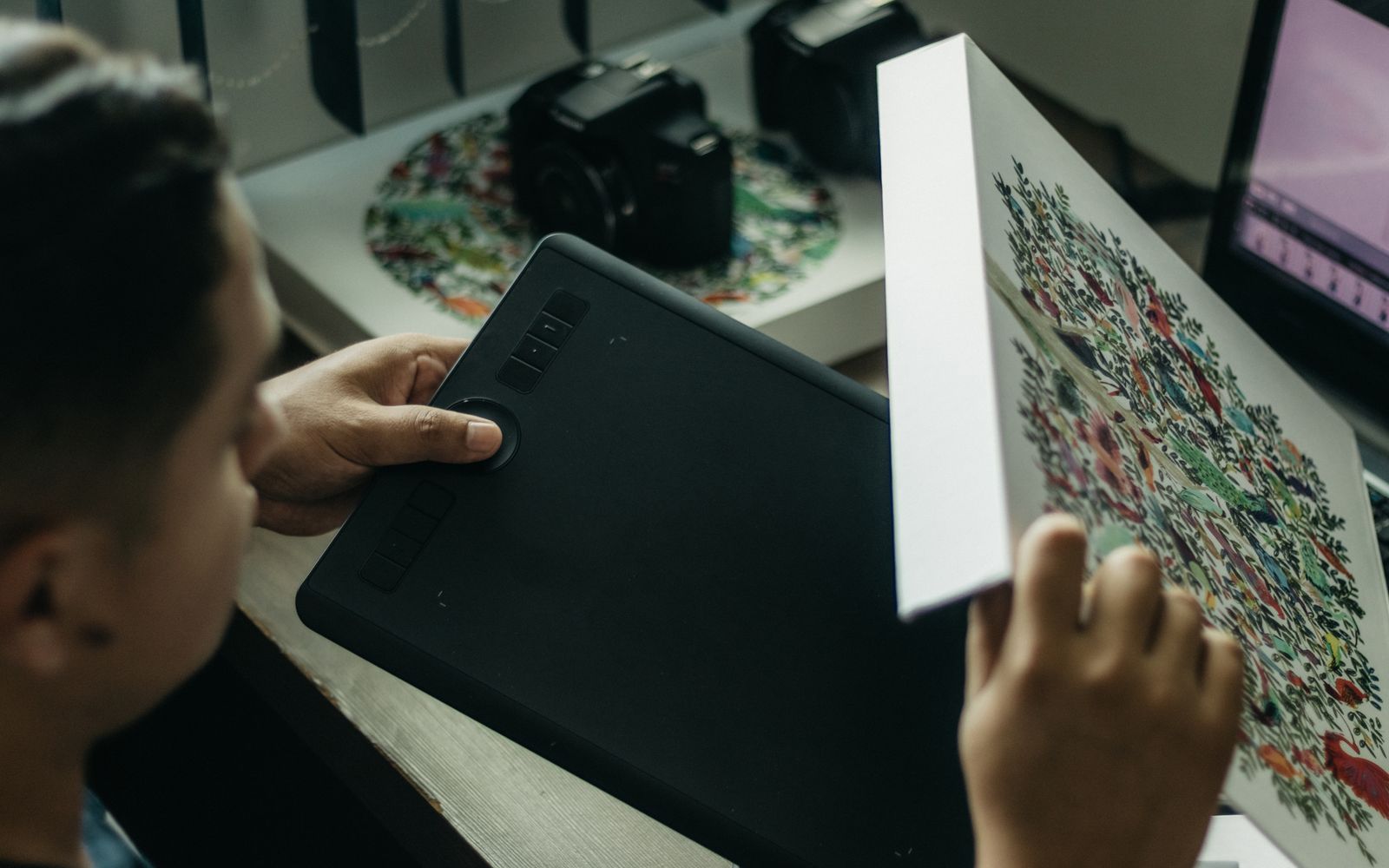 Close-up of a digital artist working with a graphics tablet indoors.