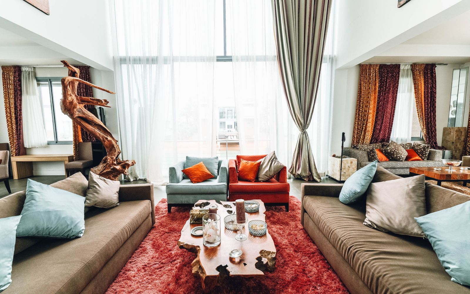 A spacious, luxurious living room with modern furnishings and natural wood decor.